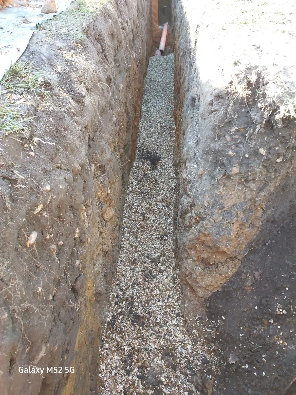 Excavated trench with gravel and drainage pipe for installation