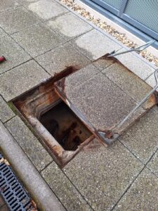 Manhole cover lifted to inspect manhole